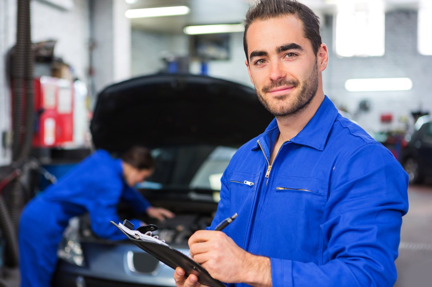 Meccanico dell'officina compila la scheda di lavorazione del veicolo